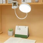 Lampe de chevet à pince, mise en scène sur un bureau.