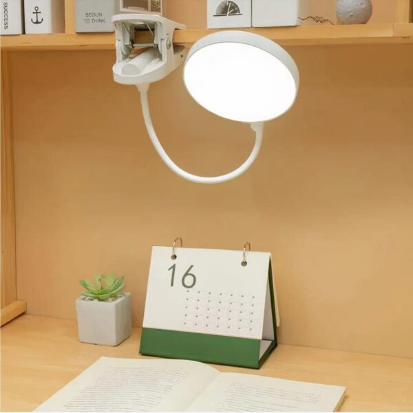 Lampe de chevet à pince, mise en scène sur un bureau.