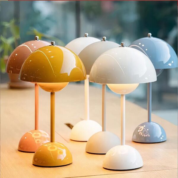 Lampe de chevet tactile scandinave dans chaque couleur disponible, posées sur une table en bois.