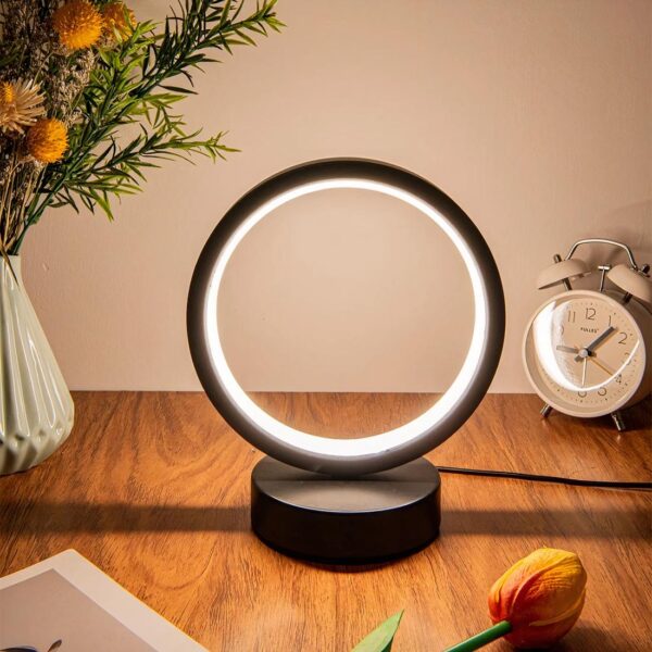 Lampe minimaliste LED allumée et posée sur un meuble en bois.