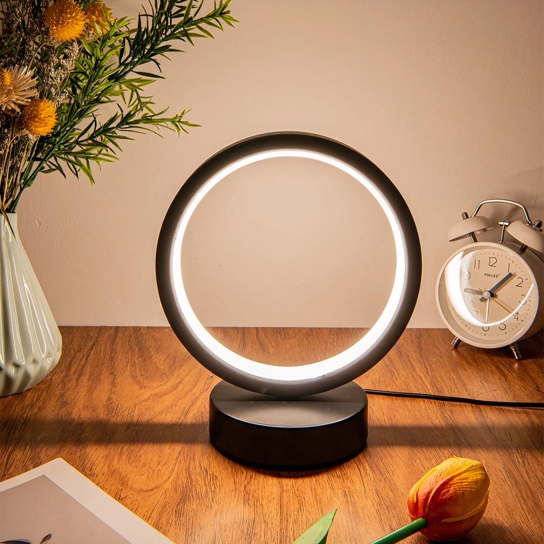 Lampe minimaliste LED allumée et posée sur un meuble en bois.