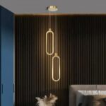 Lampe suspendue design italien mis en scène dans une chambre à coucher, à côté d'un lit.