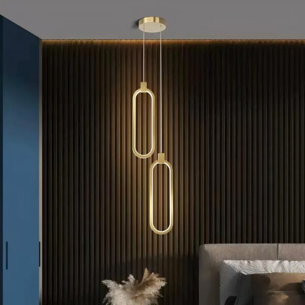 Lampe suspendue design italien mis en scène dans une chambre à coucher, à côté d'un lit.