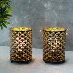 Duo de lampes de chevet en métal motif éventails, allumé et posé sur un meuble gris, sur fond gris.