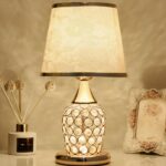 lampe de chevet ancienne en cristal posé sur une table à côté d'un cadre