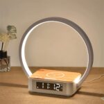 Lampe chargeur de téléphone à induction allumée et posée sur un meuble en bois.