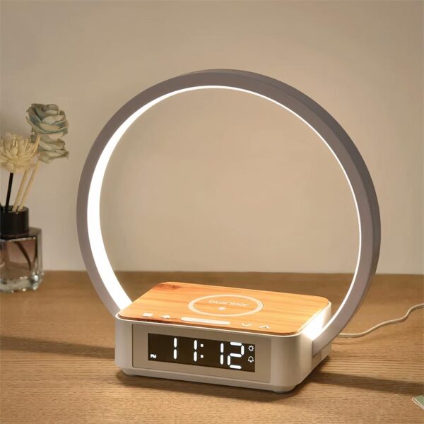Lampe chargeur de téléphone à induction allumée et posée sur un meuble en bois.