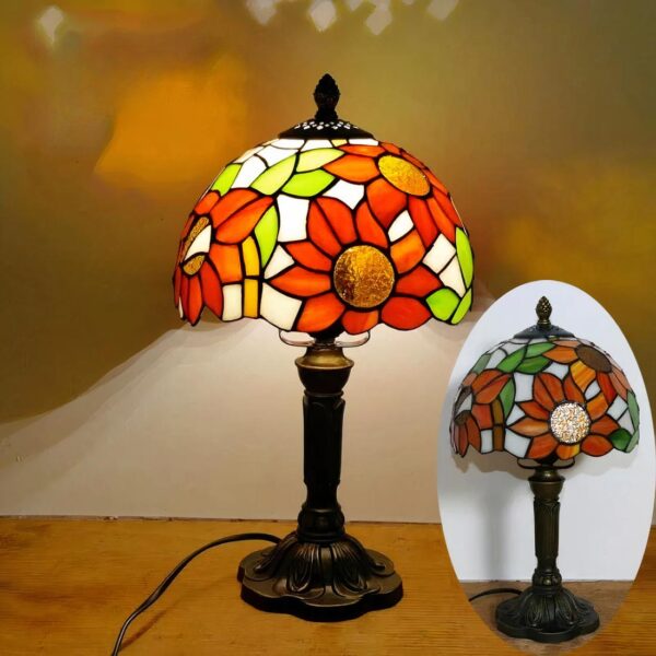 Lampe de chevet style Tiffany, colorée de différentes nuances de bleu, allumée et posée sur un support en bois.