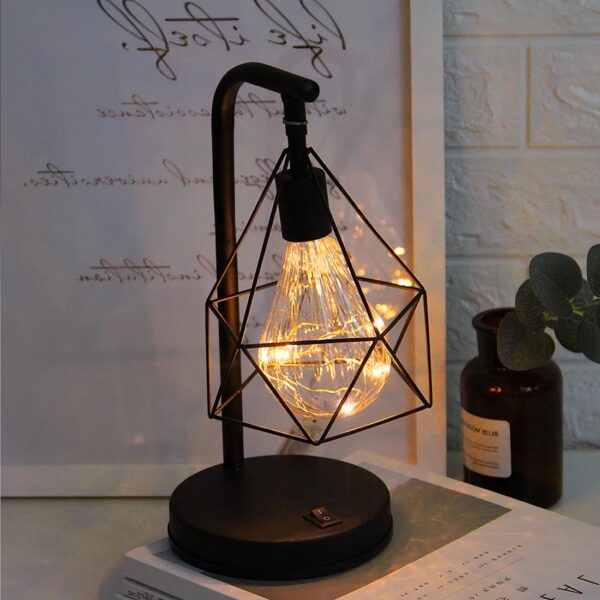 lampe de chevet industrielle noire posé sur une table devant un cadre photo