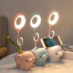 lampe de chevet en forme d'éléphant posé sur une table près d'un livre
