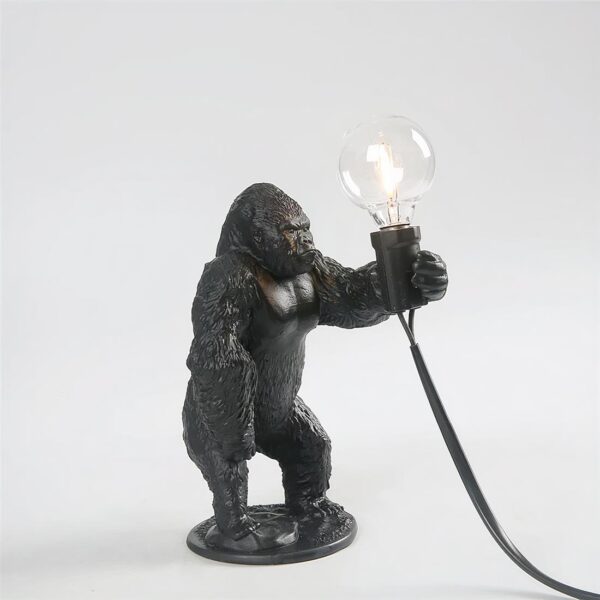 Lampe de chevet en forme de gorille, noir qui tient une ampoule dans sa main