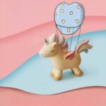 Lampe de chevet licorne colorée pour fillette avec un fond un rideau gris