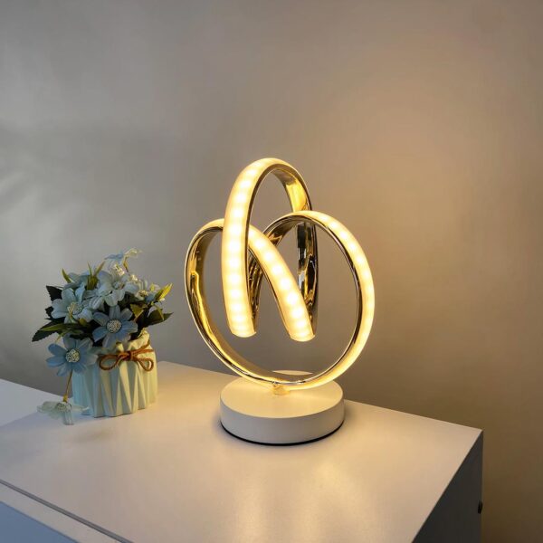 lampe de chevet moderne posé près d'une plante sur une table de chevet
