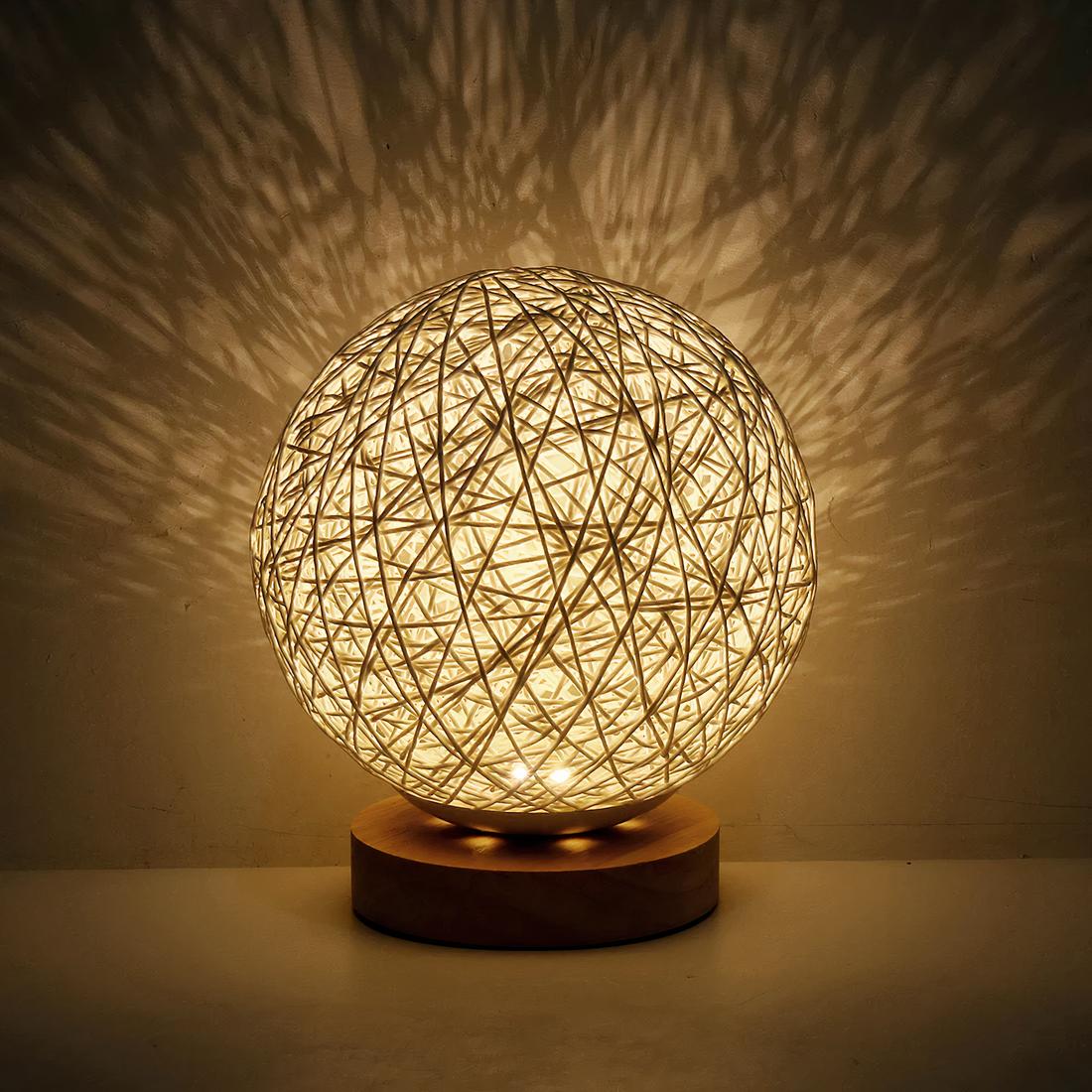 6076-l99vq3.jpg lampe de chevet naturelle en forme de boule avec un socle en bois posée sur une table