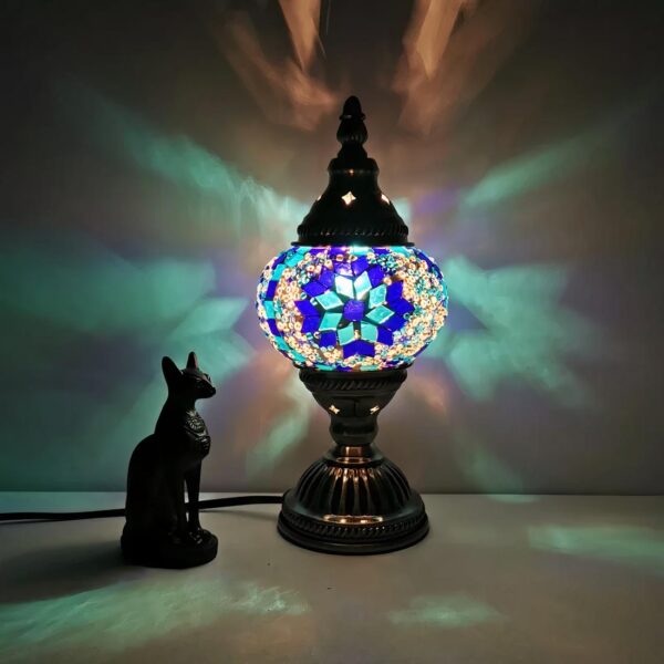lampe de chevet orientale posé sur une table près d'une statue de chat