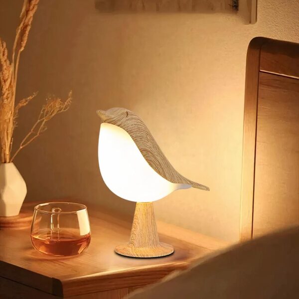 Lampe de chevet en forme d'oiseau posée sur une table de chevet à côté d'un lit