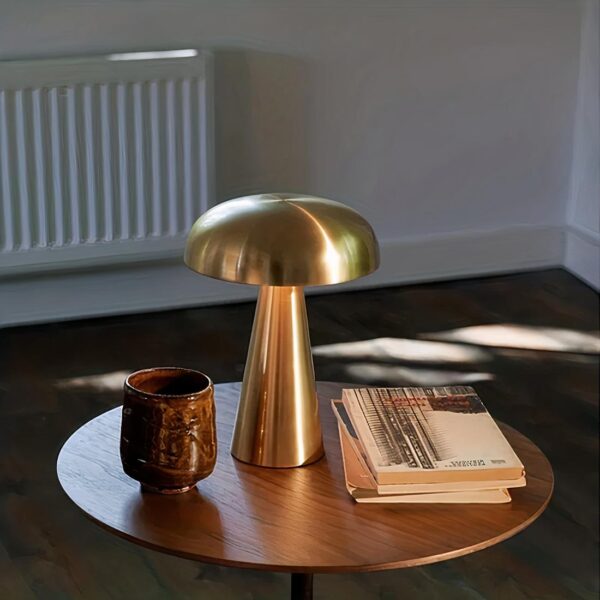 Lampe de chevet tactile en métal style champignon, posée sur une petite table de salon, avec quelques décorations d'intérieur à ses côtés.