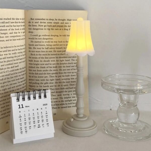 lampe de chevet vintage à led posée sur une table près d'un vase et d'un livre