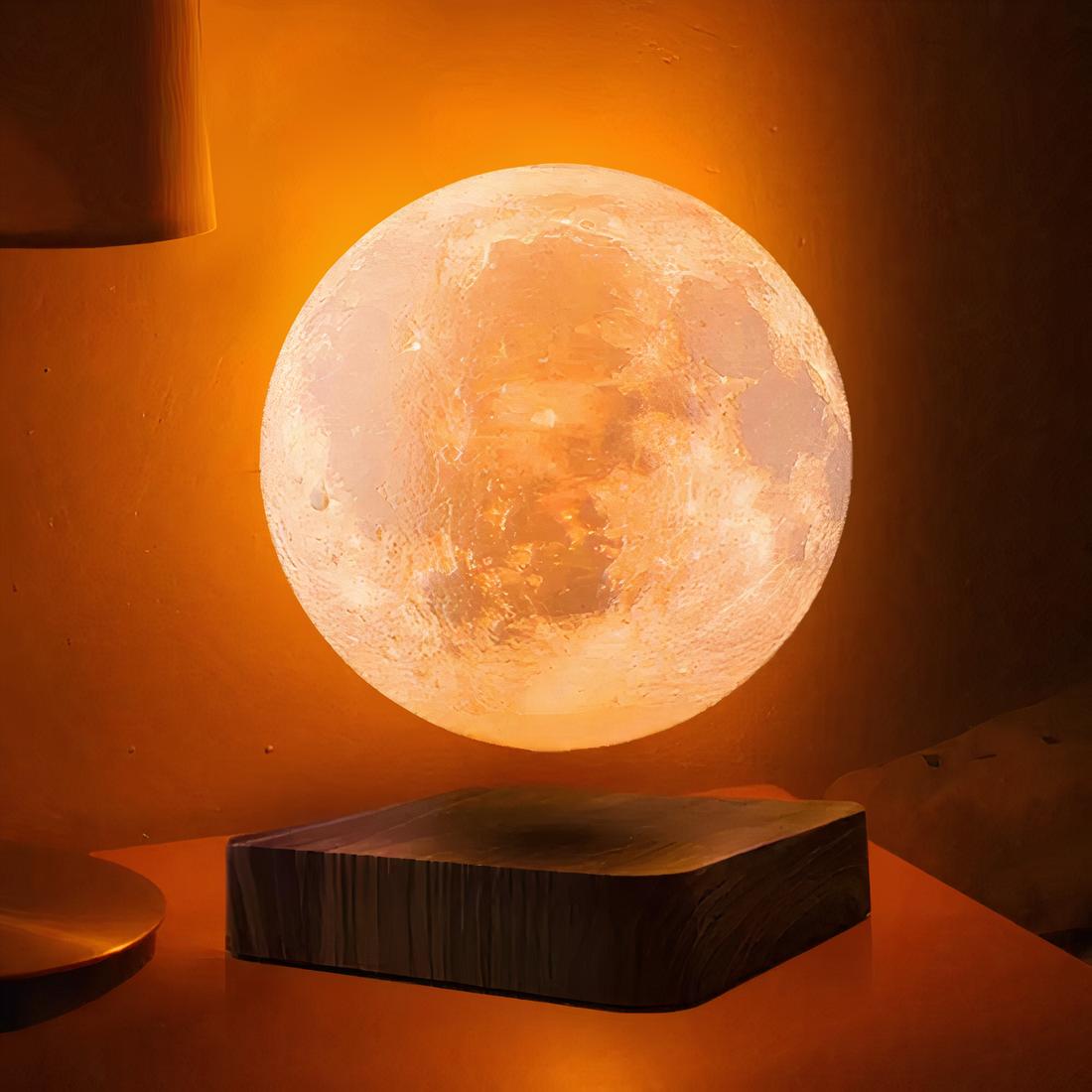 Lampe Lune flottante et rotative allumée en mode lumière chaude, sur un meuble en bois.