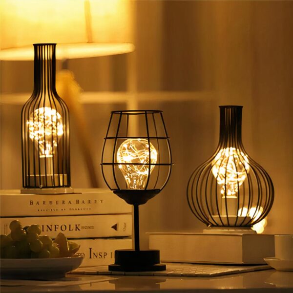 Petite lampe originale à piles à poser, posée sur un livre et allumée.