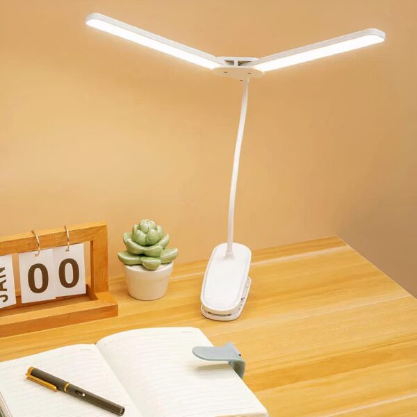 lampe de chevet pince blanche posé sur un bureau
