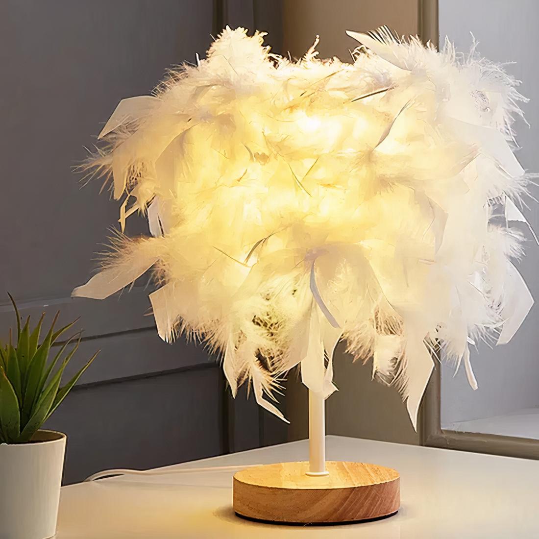 Lampe de chevet allumée en plumes avec un socle en bois, posée sur un support blanc dans une pièce.