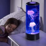 Lampe à lave méduse posé sur une table près d'un lit avec une petite fille qui dort
