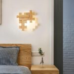 Lampe de chevet bois murale en forme de puzzle posé sur le mur au dessus d'un lit