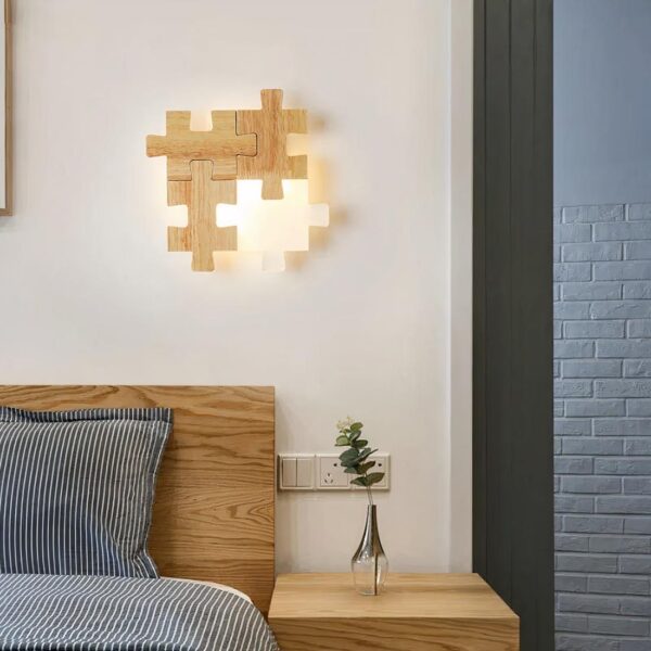 Lampe de chevet bois murale en forme de puzzle posé sur le mur au dessus d'un lit