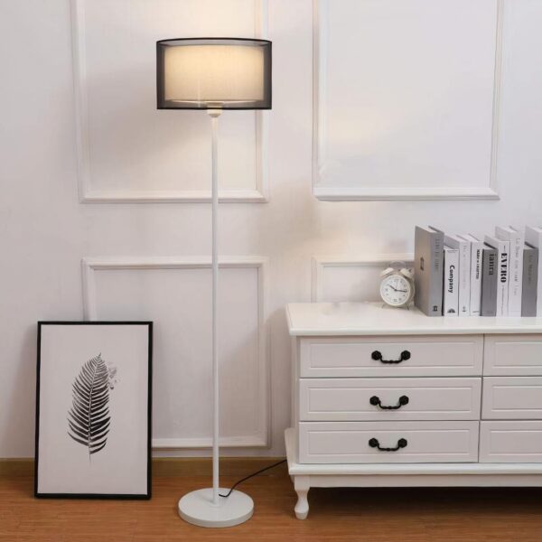 Lampe de chevet moderne en tissu posé près d'une commode et d'un cadre