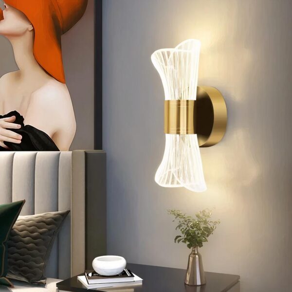 Lampe de chevet murale doré posé au mur près d'un lit