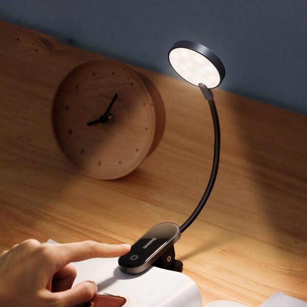 lampe de chevet pince posé sur un livre et bureau