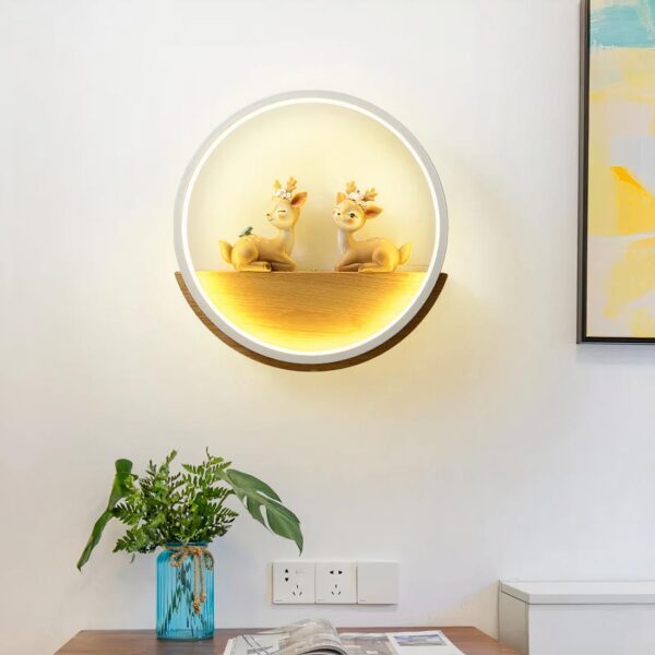 Lampe murale de forme ronde accrochée au dessus d'un meuble avec une fleur posée dessus, et un cadre à côté.