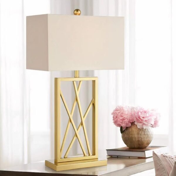 Lampe de chevet en laiton posé sur une table avec des fleurs
