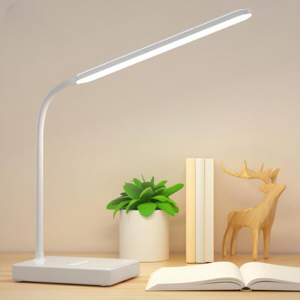 Lampe de lecture blanche avec socle rectangulaire, tige flexible et longue tête d'éclairage allumée. Posée sur un support couleur bois clair avec un libre à sa droite ouvert, Sur l'arrière, une mini plante artificielle, 3 livres et un cerf en bois.