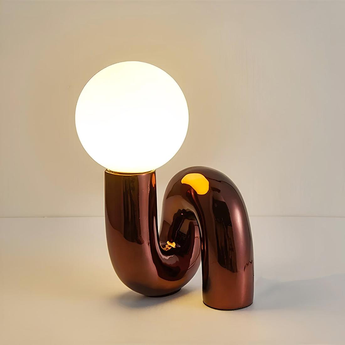IMG_04_2024_lampe_chevet_design_moderne_tube_boule_lumineuse_1 Lampe de chevet en forme de tube rouge bordeaux brillant avec une boule lumineuse allumée posée dessus.