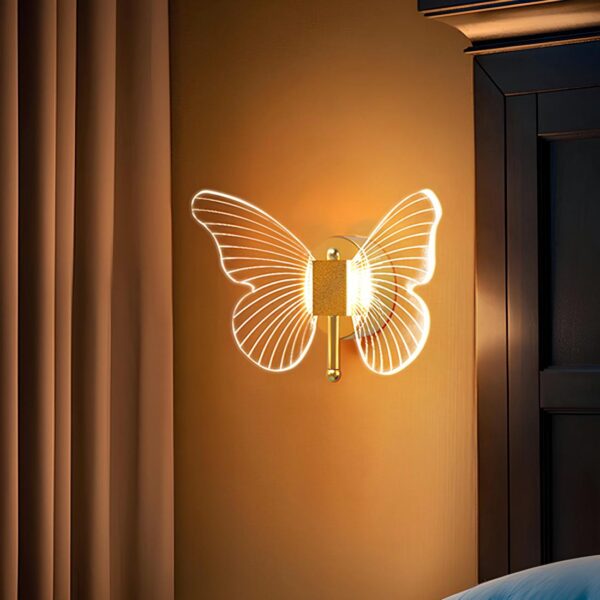 Lampe de chevet murale en forme de papillon en acrylique sur socle doré. Elle est allumée et fixée sur un mur marron. A gauche un grand rideau marron chocolat, à droite, un encadrement noir .