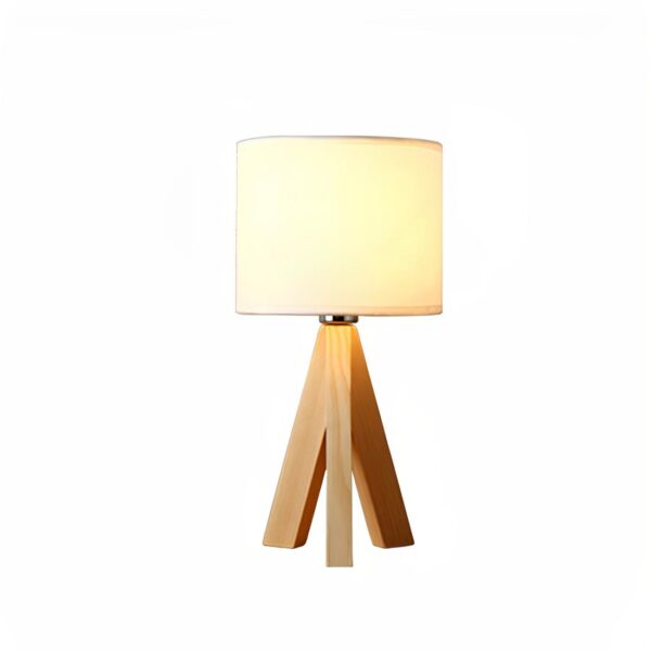Lampe de chevet avec trépied en bois et abat-jour en tissu clair laissant passer la lumière de l'ampoule. Sur fond blanc.
