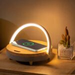lampe de chevet sans fil à charge rapide pour téléphone posé sur une table avec une plante
