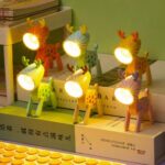6 mini lampes cerfs allumés et disposés sur des livres en deux étages
