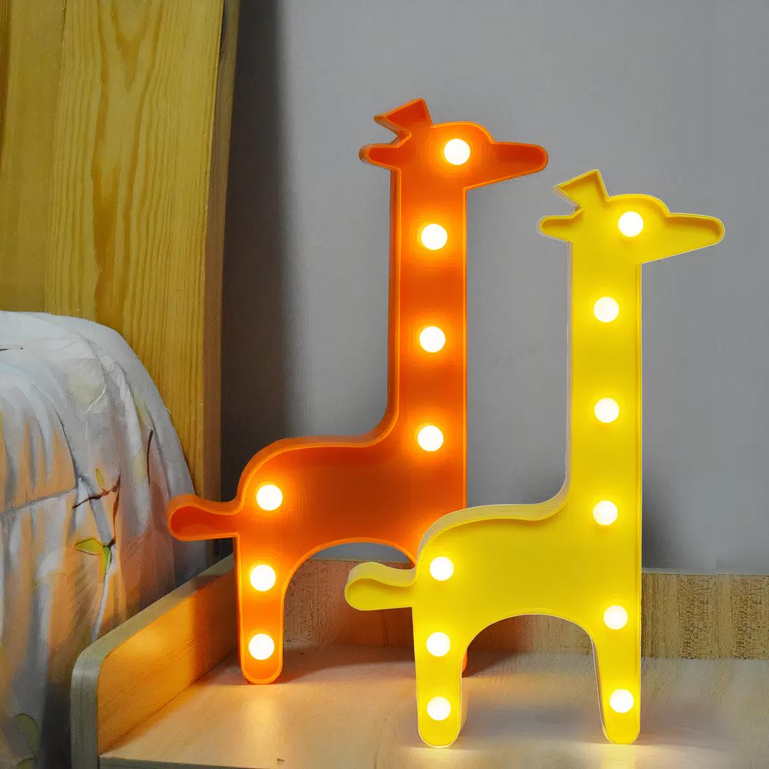 2 lampes de chevet en forme de girafe, l'une orange et l'autre jaune. Elles sont posées sur une table de chevet