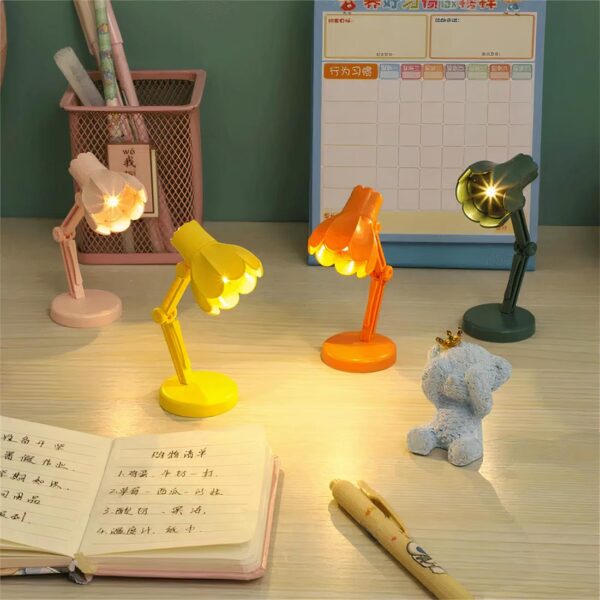 Plusieurs mini lampes avec abat-jour en fleur de plusieurs couleurs, disposées sur une table de bureau
