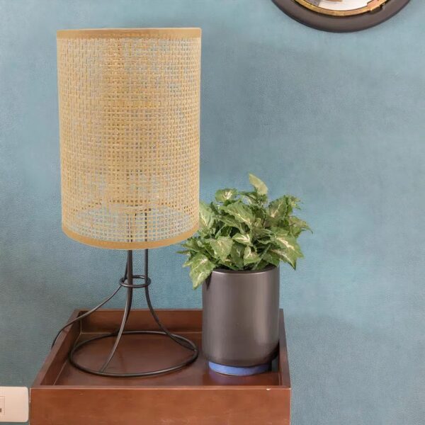 Un abat jour en rotin tissé marron sur une table en bois