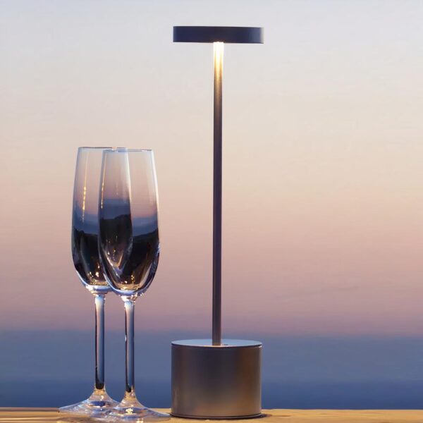 Lampe de chevet sans fil à LED moderne posée sur une table avec deux verres