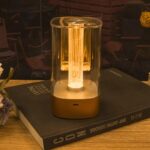 Lampe de chevet sans fil à ampoule avec filament décoratif posé sur un livre