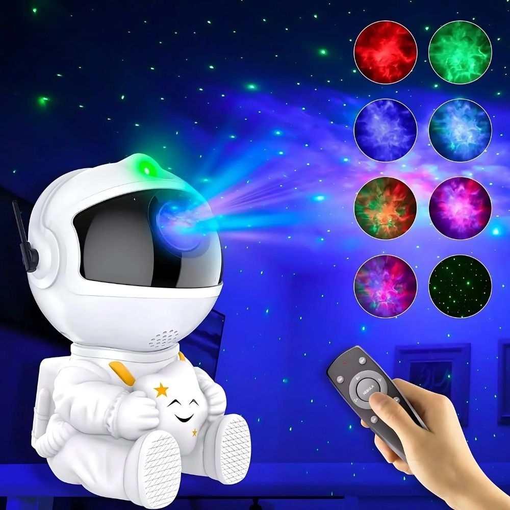 Lampe de chevet astronaute projecteur de galaxie assis de couleur blanche tenant une étoile dans ses mains. En arrière plan un voit un ciel étoilé. Sur la droite une main tenant une télécommande noire et 8 pastilles au-dessus avec différentes couleurs de galaxies.
