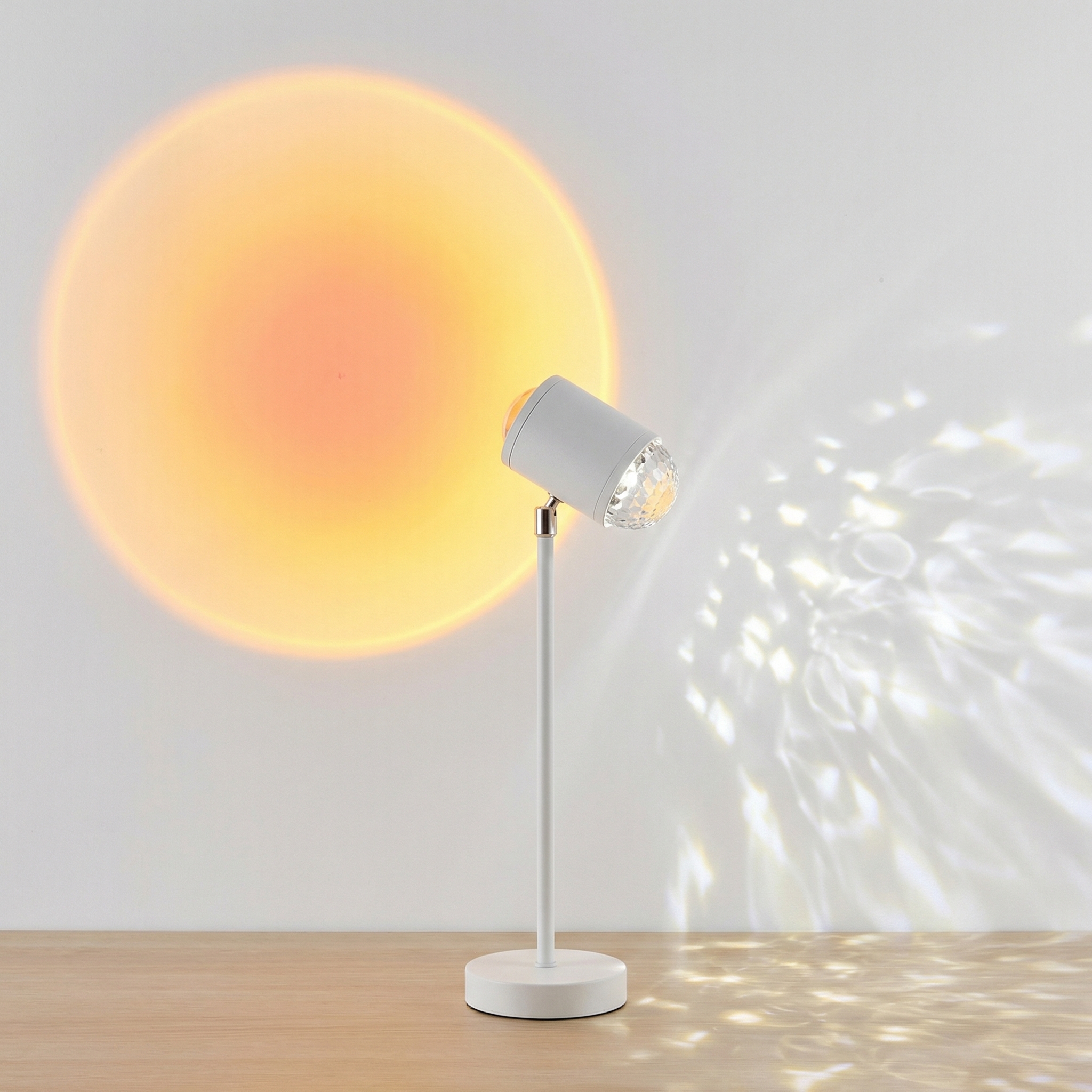 Accueil La lampe halo double projection étoilée et coucher de soleil blanche sur pied projetant un grand cercle jaune-orangé et des motifs lumineux sur mur gris.