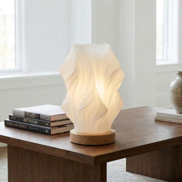 Lampe de chevet LED design rechargeable avec forme organique lumineuse, posée sur table bois, diffuse lumière douce créant ambiance moderne apaisante élégante.